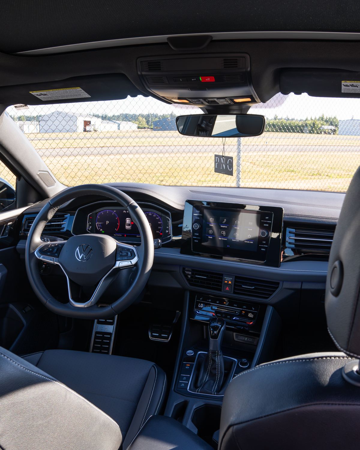 The Jetta's dashboard and digital cluster from the back seat