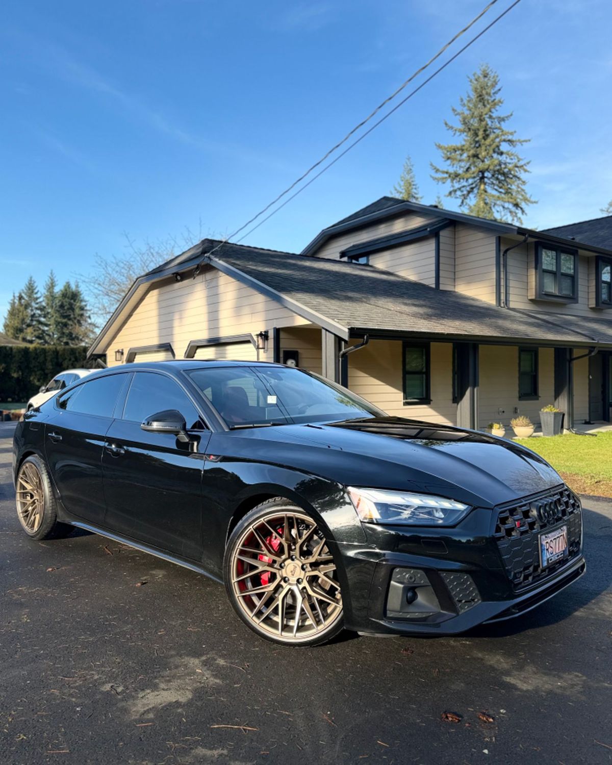 The Audi S5 in black on bronze wheels, from the front three-quarter