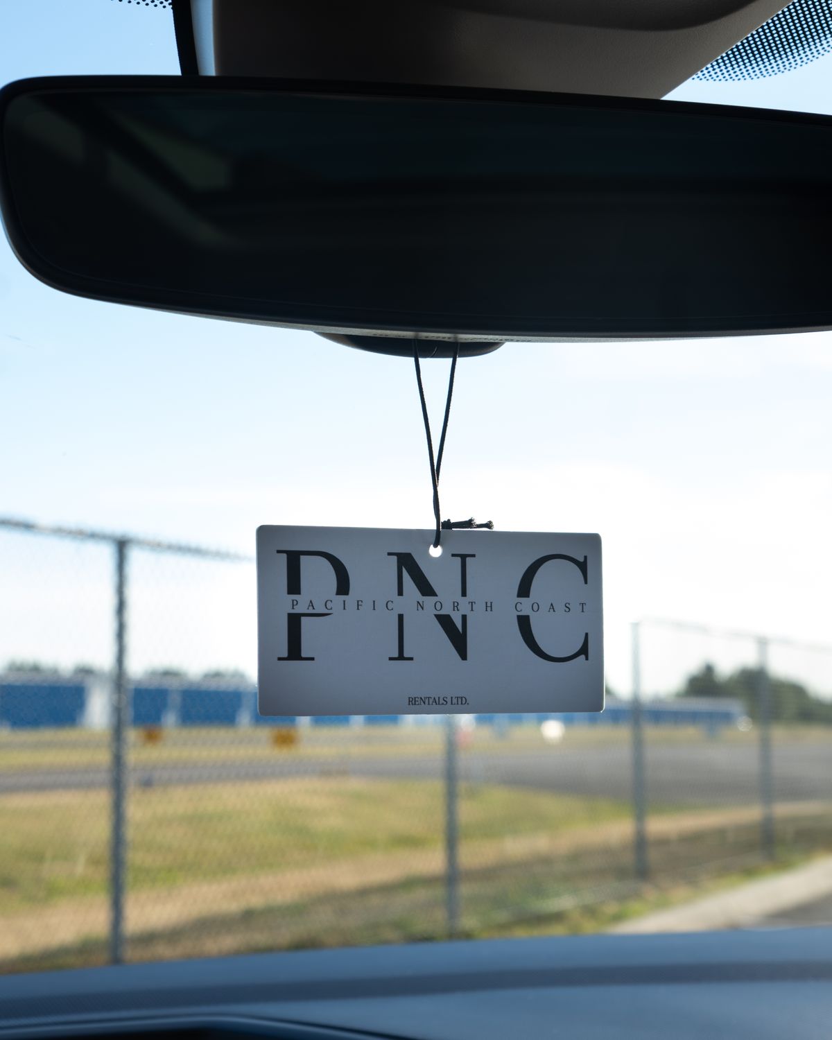 A Pacific North Coast tag hanging from the Tiguan's mirror