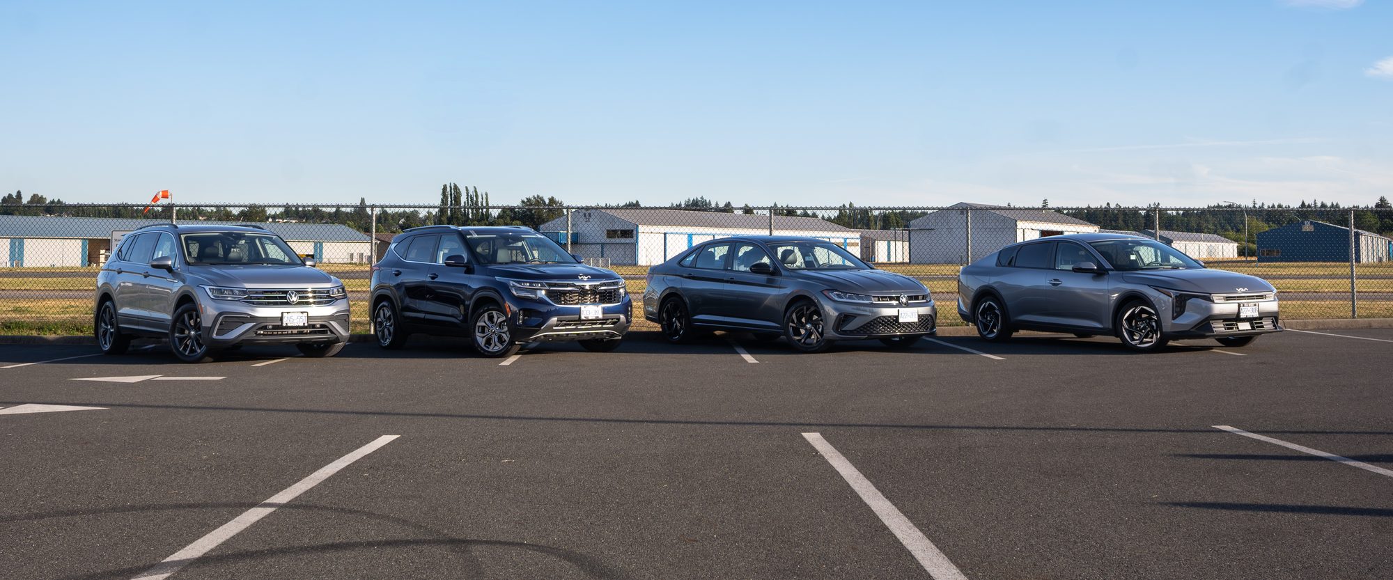 The economy fleet lined up: a Volkswagen Tiguan, a Kia Seltos, a Volkswagen Jetta and a Kia K4